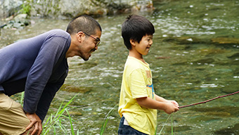はなさか学び舎河原で遊ぶ少年